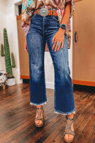 Person wearing blue jeans and a patterned top in an indoor setting